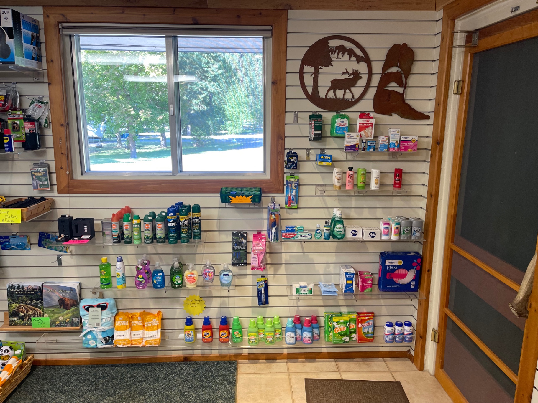 Wall display of bug spray, sunscreen, first-aid, toiletries and laundry supplies
