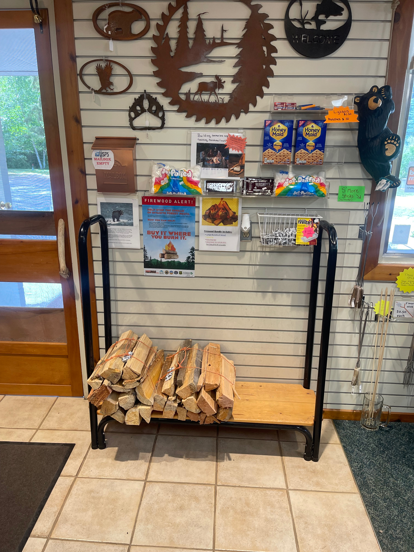 Firewood bundles with kindling and fire starter alongside s'mores supplies including graham crackers, chocolate and marshmallows
