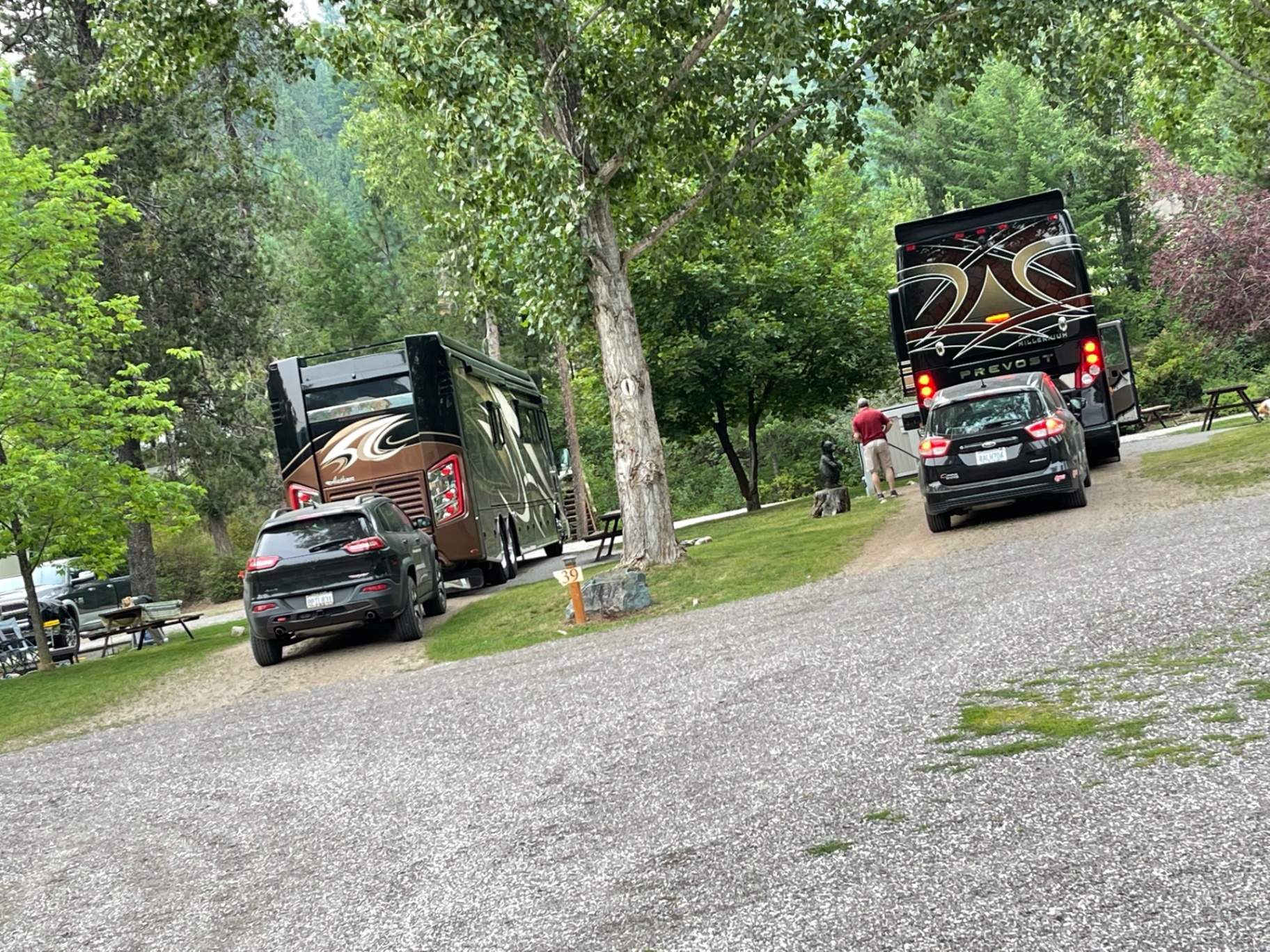 Class A motorhome and Prevost coach with toads parked on adjacent big-rig sites near site 39